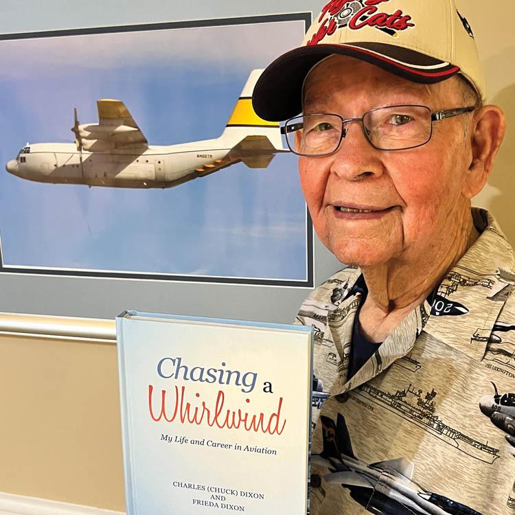 Charles Dixon holds his autobiography, "Chasing a Whirlwind"