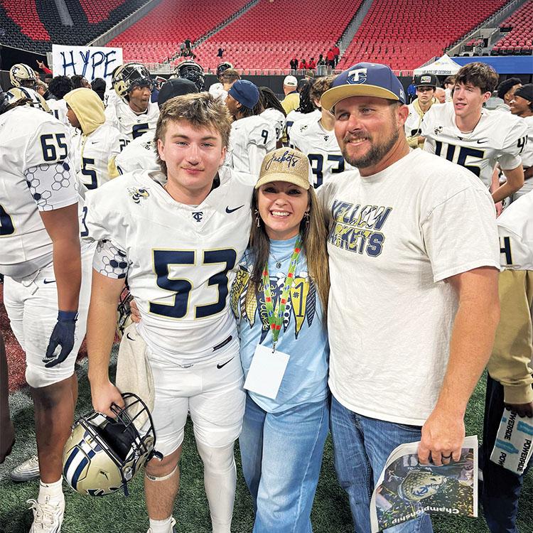 a family poses for a picture at a high school football game