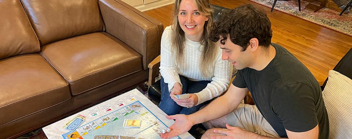 man and woman play opoly game at coffee table