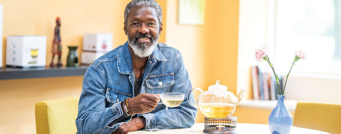man sits with tea pot and drinks tea
