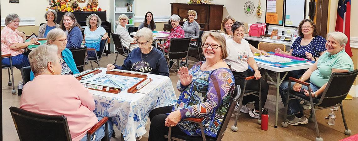 groups of people playing mahjong at round tables