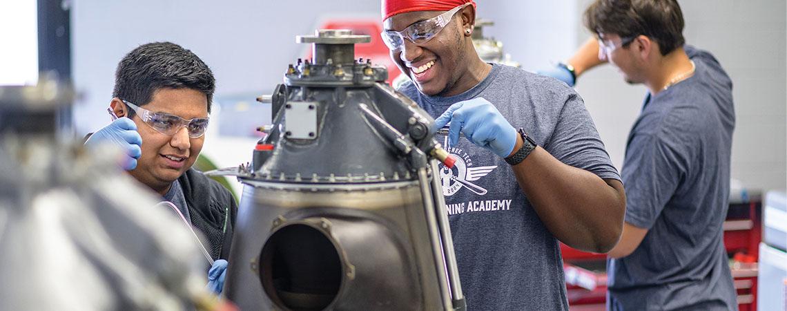 two men working on an engine part