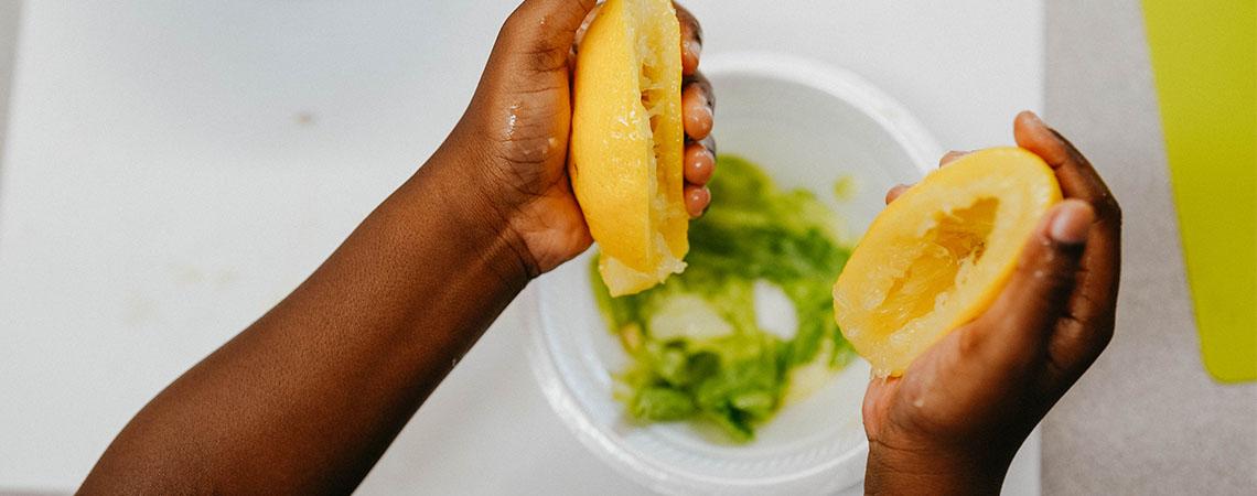 child's hands squeezing a lemon