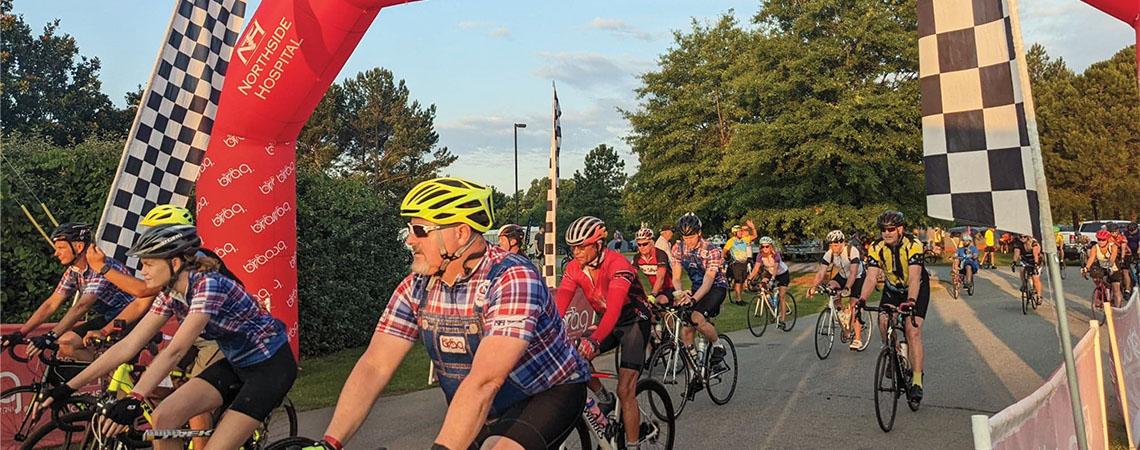 cyclists riding under a "BRAG" banner